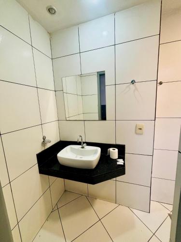 a bathroom with a sink and a mirror at Viareggio H in Niterói