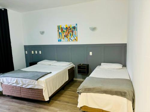 two beds sitting next to each other in a room at Viareggio H in Niterói