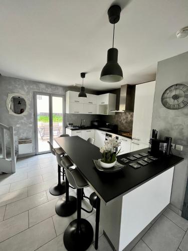 une cuisine avec une table noire et des chaises dans l'établissement Maison 6 personnes, à Saint-Michel-sur-Orge