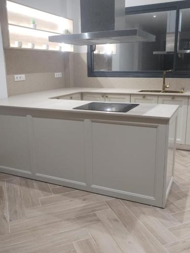 a kitchen with a white island with a sink at Villa haut standing avec piscine chauffée sans vis-à-vis et hammam in Ouled Moussa