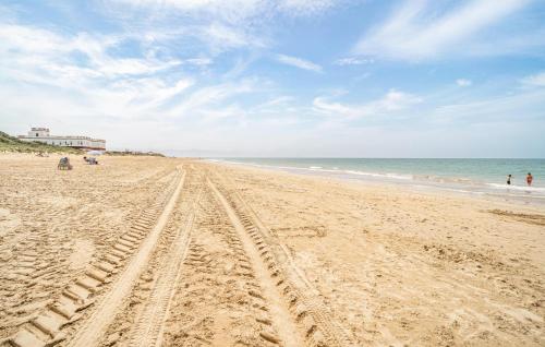 a sandy beach with tire tracks in the sand at 2 Bedroom Amazing Apartment In Chipiona in Chipiona