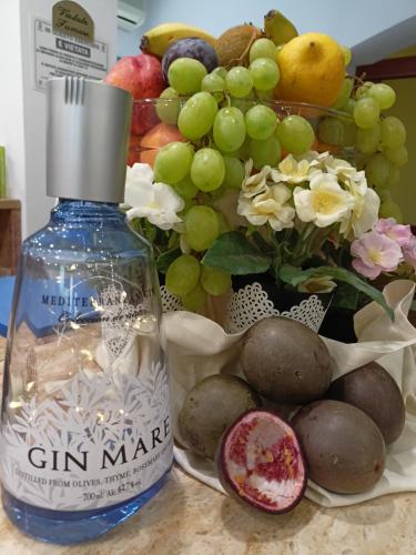 a bottle of gin maker next to a bunch of fruit at Hotel Ascot Riccione in Riccione