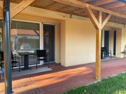 a patio with a table and chairs on a patio at Csomópont Családi Vendégház in Somogytúr