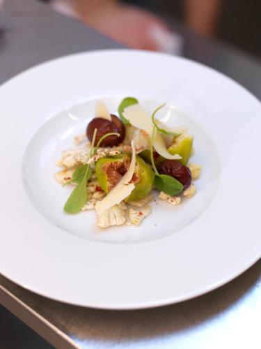 a white plate with a salad on a table at Gut Purbach in Purbach am Neusiedlersee