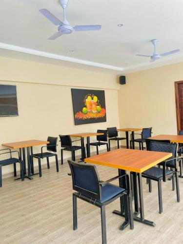 a room with tables and chairs and a painting on the wall at AIDEN HOMES AND APARTMENTS HOTEl in Koforidua