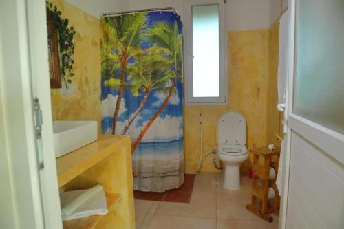 une salle de bain avec toilettes et rideau de douche dans l'établissement Bungalows Resort, à Mwanahaza