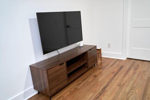 a flat screen tv on top of a wooden entertainment center at Modern & Spacious Home Near Downtown Atlanta in Atlanta