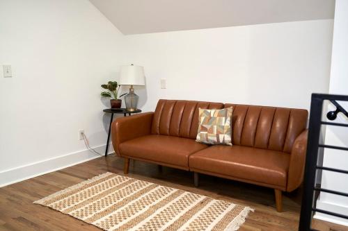 a brown leather couch in a living room at Modern & Spacious Home Near Downtown Atlanta in Atlanta