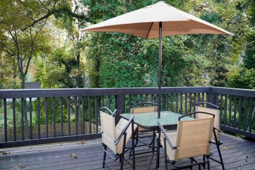 a table and chairs with an umbrella on a deck at Modern & Spacious Home Near Downtown Atlanta in Atlanta