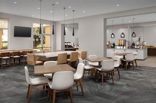 a restaurant with tables and chairs and a kitchen at Residence Inn by Marriott Anaheim Resort Area/Garden Grove in Anaheim