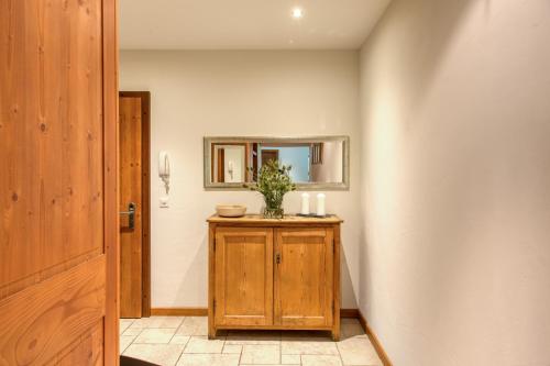 a hallway with a mirror and a wooden cabinet at Lodge 1, Hot Tub And Bbq in Champéry