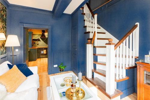 a living room with blue walls and a staircase at Wohnen im Carl Maria von Weber Geburtshaus in Eutin
