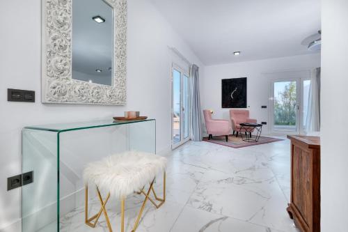 a white living room with a stool and a mirror at Casa Serena 10 Boutique- Adults Only-Breakfast Included in Mácher