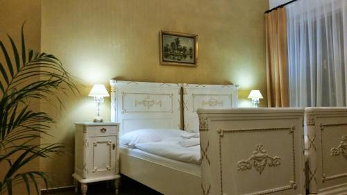 a bedroom with a white bed with two lamps and a plant at Old Prague House in Prague