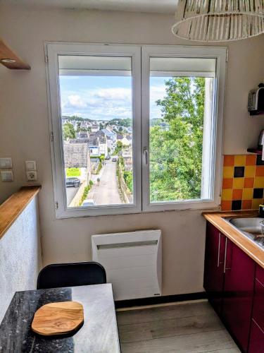 - une cuisine avec 2 fenêtres, une table et un évier dans l'établissement Kerjana, à Concarneau