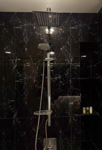 a bathroom with a microphone on a black tiled wall at Mida Grande - 903 in Ban Lum Fuang