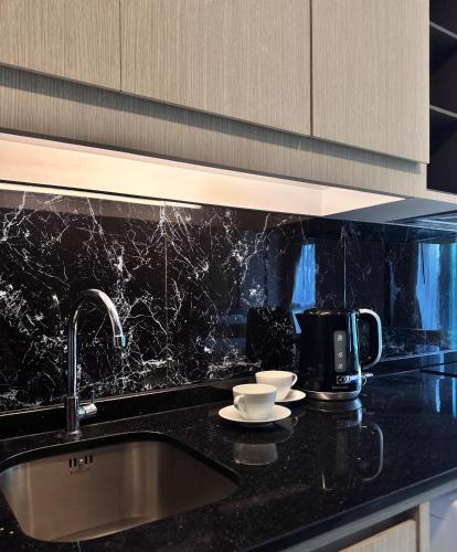 a kitchen counter with a sink and a coffee maker at Mida Grande - 903 in Ban Lum Fuang