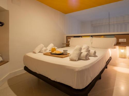 a bedroom with a bed with a tray of food on it at Bhost - Palacete del Águila in Córdoba