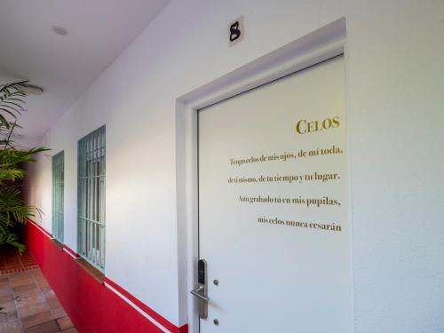 a door with a sign on the side of a building at Bhost - Palacete del Águila in Córdoba