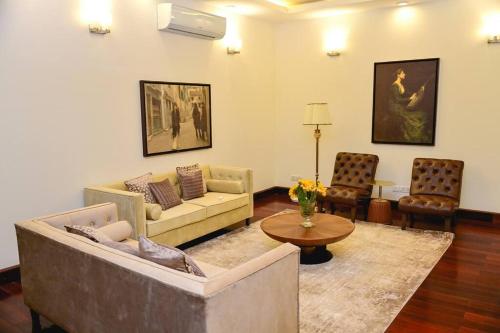a living room with a couch and a table and chairs at Udman Luxe Villa Chattarpur in New Delhi