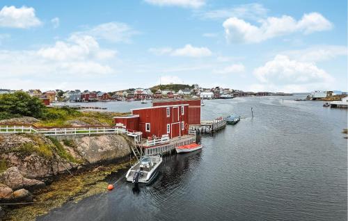 a boat docked in a river with a red building at 3 Bedroom Amazing Home In Sula in Sula