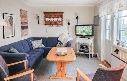a living room with a blue couch and a tv at 3 Bedroom Amazing Home In Sula in Sula