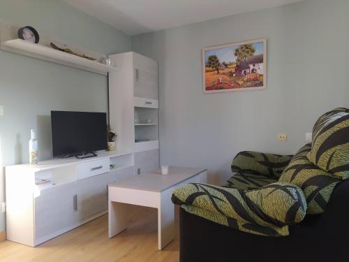 a living room with a couch and a tv and a table at Casa Marcelino in Reinante