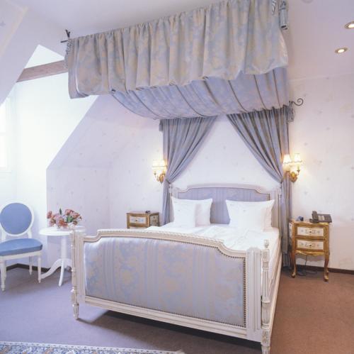 Кровать или кровати в номере Schloßhotel Kurfürstliches Amtshaus Dauner Burg