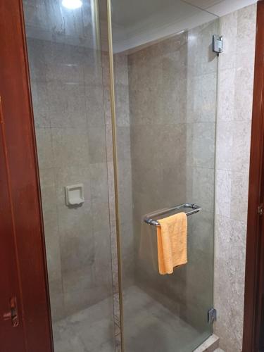 a shower with a glass door and a towel at Kuala Lumpur Grand service suite at Times Square in Kuala Lumpur