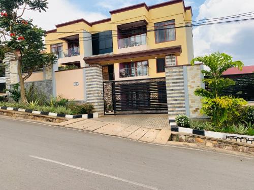 a yellow building on the side of a street at ROBERT Villa APARTMENT in Kigali