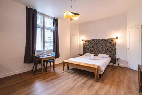 une chambre avec un lit, un bureau et une fenêtre dans l'établissement Bulle, vue Cathédrale incroyable, à Reims