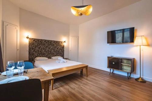 une chambre avec un lit, une table et une télévision dans l'établissement Bulle, vue Cathédrale incroyable, à Reims