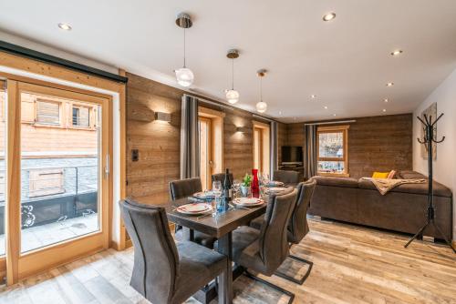 une salle à manger avec une table, des chaises et un canapé dans l'établissement OURSON - Appartement 3 chambres / 3 salles de bains, à Morzine