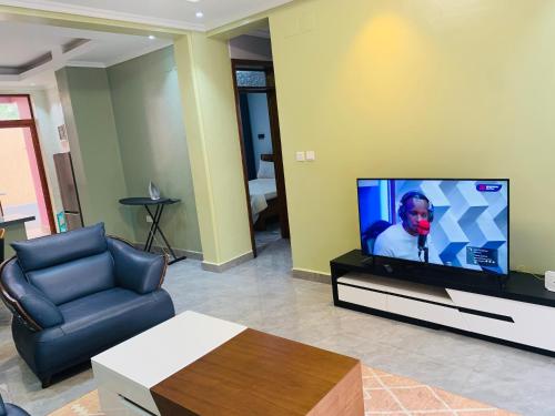 a living room with a couch and a television at ROBERT Villa APARTMENT in Kigali