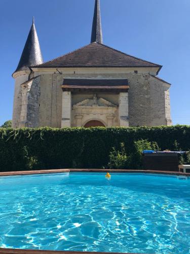 une grande piscine devant un immeuble dans l'établissement Espace Piscine et SPA Villa des Cortins, à Dierrey-Saint-Julien