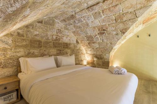 a bedroom with a bed in a stone wall at Casa Batroun Lofts in Batroûn