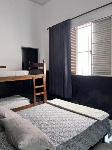 a bedroom with two bunk beds and a window at Hotel Loren in Bauru