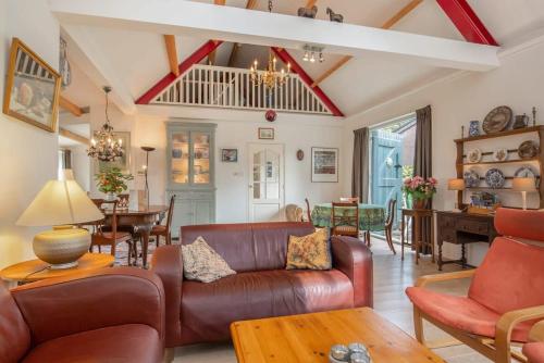 a living room with a couch and a table at Hello Zeeland - Vakantiehuis Het Blauwe Hof in Koudekerke
