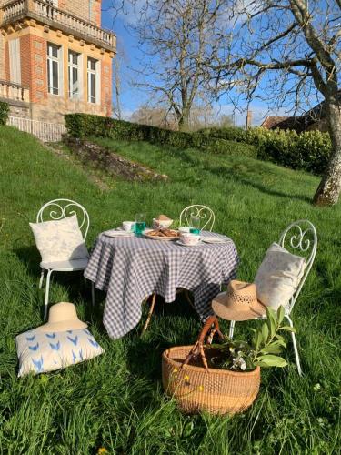 a picnic table and chairs in the grass in a yard at Castle Of Saint Germain Des Rives in Saint-Germain-des-Rives