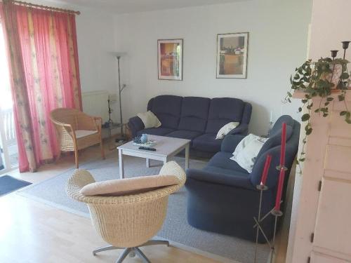 a living room with a blue couch and a table at Hello Zeeland - Vakantiehuis Zwin 174 in Breskens
