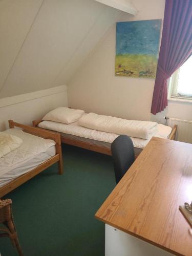 a small room with two beds and a table at Hello Zeeland - Vakantiehuis Zwin 174 in Breskens