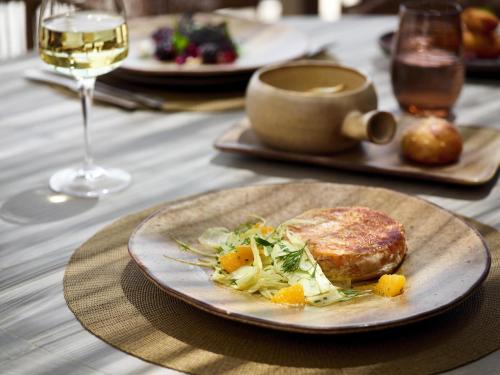 a table with a plate of food and a glass of wine at Ikos Aria in Kefalos