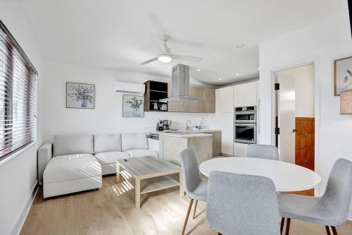 a kitchen and a living room with a table and chairs at Waves On Walnut - Beach Access in Hollywood