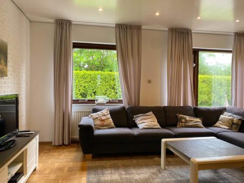 a living room with a couch and a tv at Hello Zeeland - Vakantiehuis Het Heem 39 in Breskens