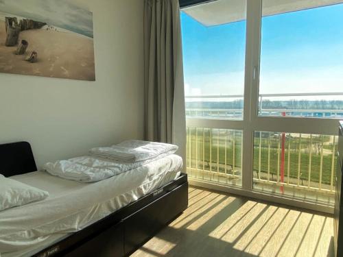 ブレスケンスにあるHello Zeeland - Appartement Port Scaldis 09-072のベッドと大きな窓のある寝室