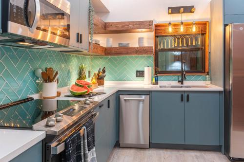 a kitchen with blue cabinets and a sink at Artisan Oasis-hot Tub Fire Pit 8bd Whole House in Indianapolis