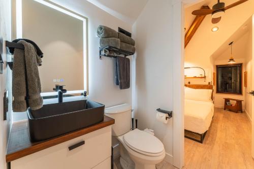 a bathroom with a sink and a toilet and a bed at Artisan Oasis-hot Tub Fire Pit 8bd Whole House in Indianapolis