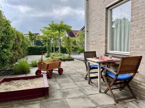 a patio with a table and chairs and a stroller at Hello Zeeland - Vakantiehuis Zwin 182 in Breskens