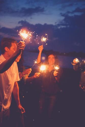 a group of people holding sparklers on the beach at Ikos Aria in Kefalos