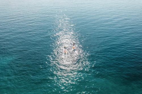 two people swimming in the water in the ocean at Ikos Aria in Kefalos